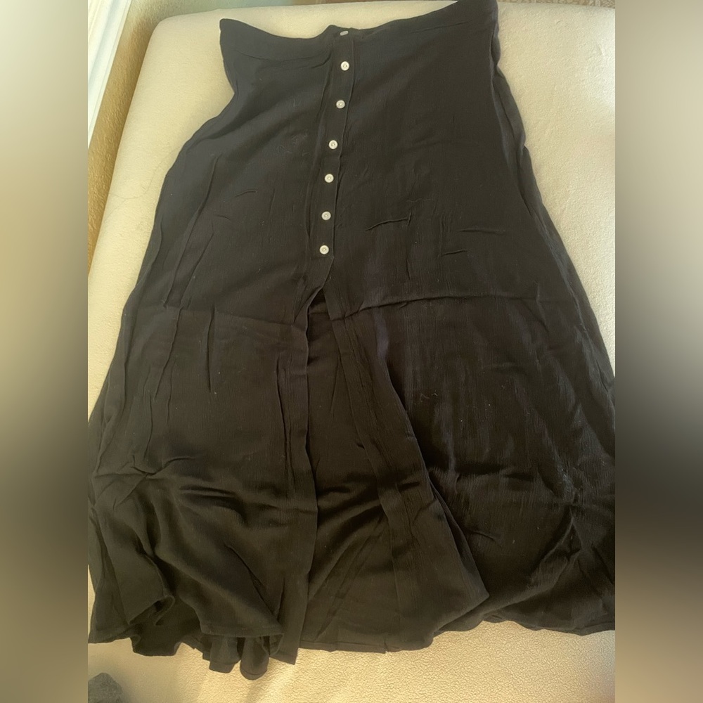 Black midi skirt. Button in the front with a slit.